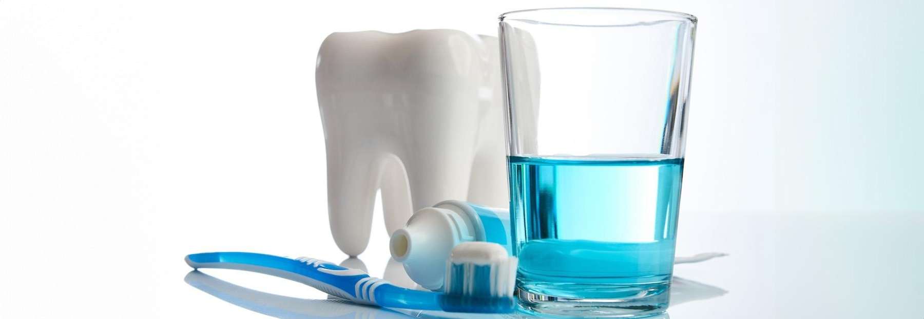 A collection of oral hygiene products arranged on a reflective surface.