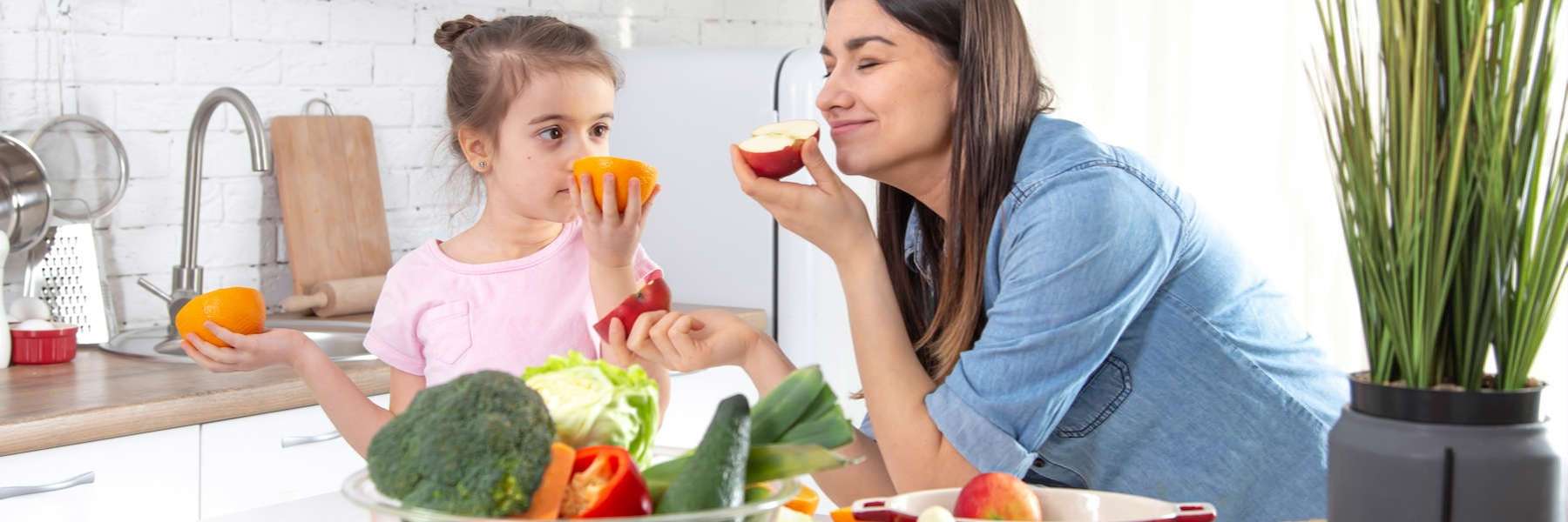Mother and daughter smelling fruit illustrating Should I Ask Google or My Dentist?